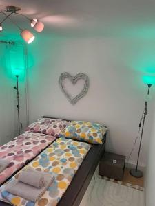 ein Schlafzimmer mit einem Bett mit einem Herz an der Wand in der Unterkunft PS Apartment in Graz