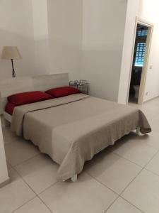 um quarto com uma cama grande e almofadas vermelhas em Appartamento Suite Antiche Terme - Zero Barriere em Acqui Terme