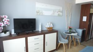 salon z telewizorem i stołem w obiekcie Apartament Nad Parsętą w Kołobrzegu