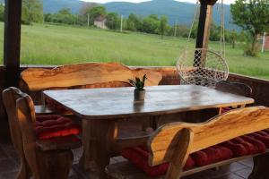 a table and chairs on a porch with a swing at Apartman Tonković in Sinac