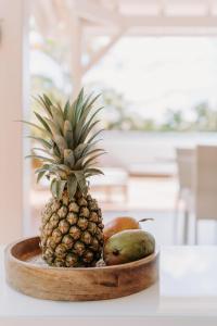 プティ・ブールにあるHabitation TABANONのテーブルの上にパイナップルと他の果物が載った皿