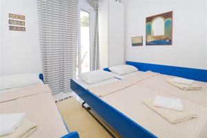 une chambre avec deux lits et une fenêtre dans l'établissement Feni Traditional House Loutra 2 bedrooms 6 guests, à Agia Paraskevi