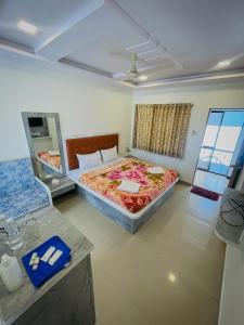 ein Schlafzimmer mit einem großen Bett und einem Spiegel in der Unterkunft Hill Side Heaven Residency in Mahabaleshwar