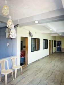 Zimmer mit 2 Stühlen, einem Tisch und Lampen in der Unterkunft Hill Side Heaven Residency in Mahabaleshwar