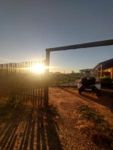 a car parked in front of a building with the sun shining at Chalés Aconchego in Pirenópolis