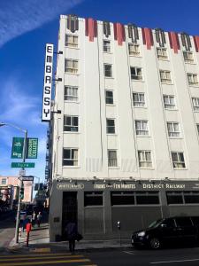 een groot wit gebouw met een bord erop bij EMBASSY HOTEL in San Francisco