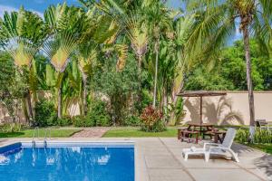 einen Pool mit einem Tisch, einem Picknicktisch und Palmen in der Unterkunft Fiesta Inn Colima in Colima