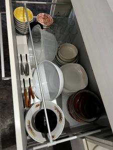 einer Schublade mit Tellern, Schalen und Küchenutensilien in der Unterkunft 貸し切りゲストハウスsai2nd in Yasugi