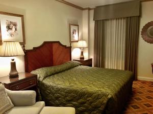 a hotel room with a bed and a chair at EMBASSY HOTEL in San Francisco