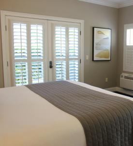 a bedroom with a large bed and windows at Bel Abri Napa Valley Inn in Napa