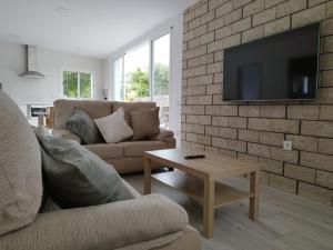 a living room with a couch and a tv on a brick wall at Finca de Luna in La Orotava