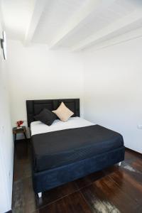a bedroom with a bed with a black and white comforter at Villa Angel Lampedusa. in Lampedusa