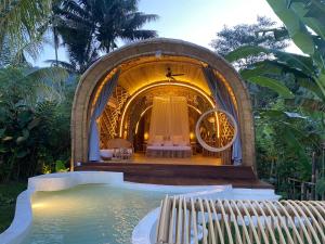 a small house with a pool of water in front of it at Gladak di Uma Bali in Sidemen