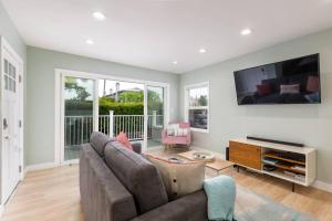 a living room with a couch and a flat screen tv at Beach House In The Heart Of PB in San Diego