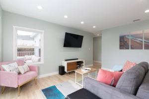 a living room with two couches and a tv at Beach House In The Heart Of PB in San Diego