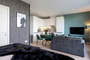 um quarto com um sofá, uma mesa e uma cozinha em Palm Tree House - Panther em Orpington