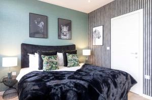 um quarto com uma cama grande e um cobertor preto em Palm Tree House - Panther em Orpington