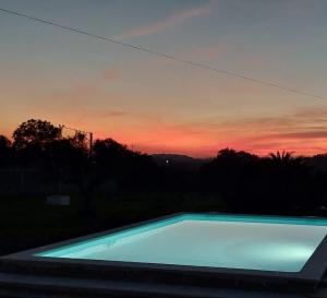 una piscina con un tramonto sullo sfondo di Casa Alegria - Vista da Serra a Tomar Altre 7 foto