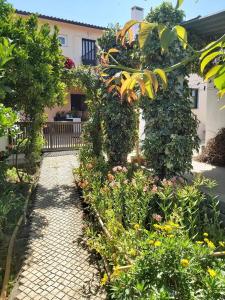 un jardín con una pasarela con flores y plantas en Casa Alegria - Vista da Serra, 