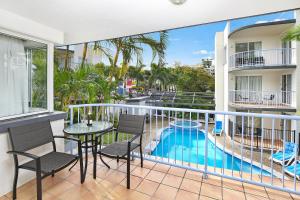a patio with a pool and chairs and a pool table at Beachside Mooloolaba in Mooloolaba