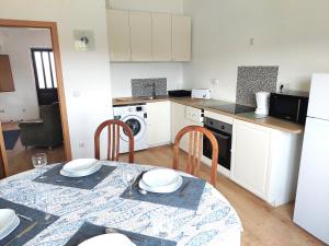 una cucina con tavolo e sedie e una cucina con piano cottura di Casa Alegria - Vista da Serra a Tomar