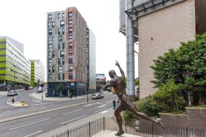 uma estátua de uma pessoa a saltar numa rua da cidade em Stylish Studios and Ensuites Steps from Newcastle University at St James Point em Newcastle upon Tyne