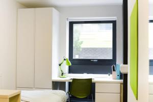 - une chambre avec un bureau, une fenêtre et une chaise verte dans l'établissement Stylish Studios and Ensuites Steps from Newcastle University at St James Point, à Newcastle upon Tyne