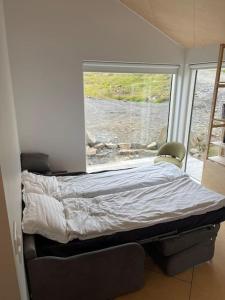 - une chambre avec un lit en face d'une fenêtre dans l'établissement Peaceful Lakeside Cabin, à Reynivellir
