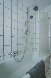 een douche met een douchekop in de badkamer bij Wohnen über einem mediterranen Restaurant,Apartment 2 oder 3 in Leipzig