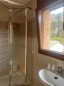 baño con ducha, lavabo y ventana en Casa rural Gerardo en Armallones