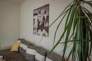 een woonkamer met een bank en een plant bij Wohnen über einem mediterranen Restaurant,Apartment 2 oder 3 in Leipzig