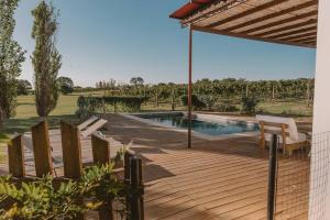 a wooden deck with a swimming pool in a yard at Casa Campotinto- Paz en Carmelo in Carmelo