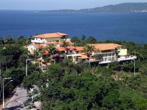 a house on a hill next to the ocean at Hotel Pousada 7 Mares in Itapema