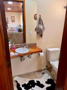 カンポス・ド・ジョルドンにあるCasa Bela vistaのバスルーム(洗面台、トイレ、鏡付)