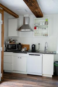 于林根-比肯多夫Wallys Hüsli im Schwarzwald的厨房配有白色橱柜和炉灶。