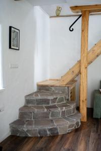 a stone staircase in a room with a wooden beam at Wallys Hüsli im Schwarzwald in Ühlingen-Birkendorf