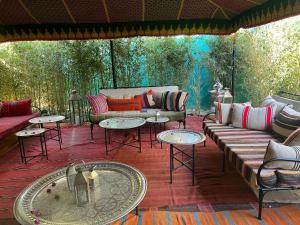 una sala de estar con sofás y mesas en un patio en Riad Majdoulina chez JIJI, en Marrakech