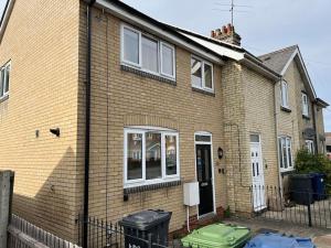 a brown brick house with windows and a fence at Doctors, Nurses, Families and contractors welcome in Huntingdon