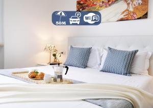 un letto bianco con un vassoio di cibo sopra di HoliHome_Casa di Sara a Tortoreto