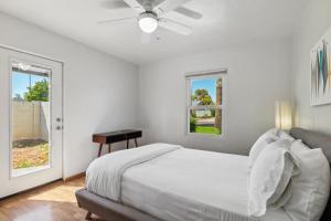 a white bedroom with a bed and a window at Palmera Place Uptown Phoenix in Phoenix