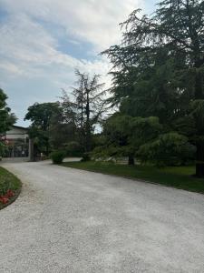 uma entrada de cascalho em frente a uma casa com árvores em B&B La Terrazza em Pozzolengo