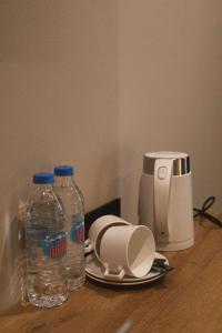 a table with two bottles of water and a coffee maker at Central Hotel Kutaisi in Kutaisi