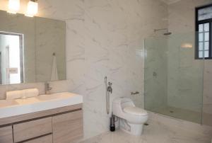 een badkamer met een wastafel, een douche en een toilet bij CASA BIANCA Bella Vista in Panama-Stad