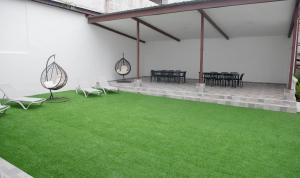 een kamer met groen gras en tafels en stoelen bij CASA BIANCA Bella Vista in Panama-Stad