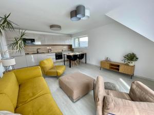 a living room with a yellow couch and a kitchen at Apartmán Bystřice in Bystřice nad Pernštejnem