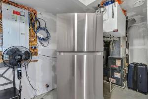 eine Küche mit einem Kühlschrank und einem Ventilator in der Unterkunft ModernSuite*NearAirport*2Queens*2Bedroom*FullKitchen in Edmonton