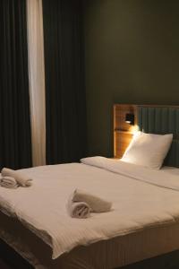 Dos camas en una habitación de hotel con toallas. en Central Hotel Kutaisi en Kutaisi