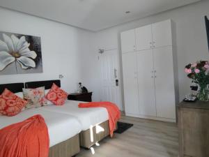 a bedroom with a large bed with red pillows at Point B Guest House -Sustainable Solar Energy in Cape Town