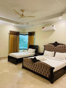 a bedroom with two beds and a couch at Executive Galaxy Guest House in Islamabad