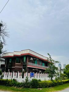 a building with a white fence in front of it at Executive Galaxy Guest House Islamabad in Islamabad